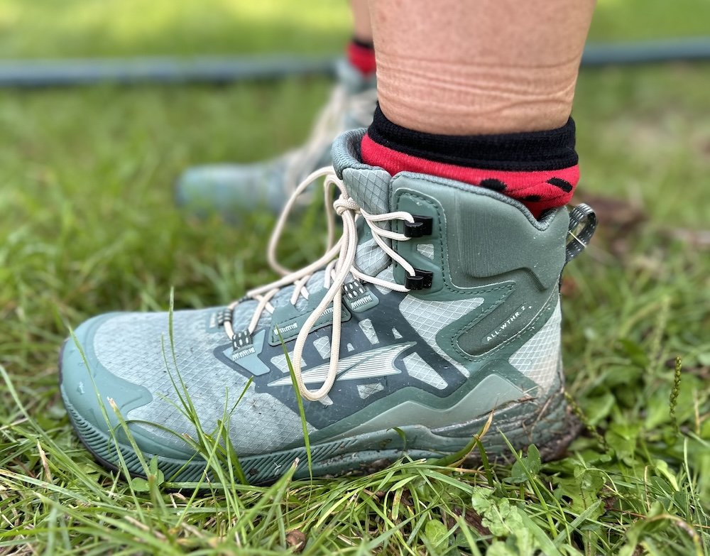 A close up side view of a person's feet wearing Altra Lone Peak All Weather Mid wide toe box hiking boots