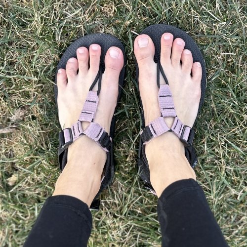 Top down view of a person's feet in Bedrock Cairn sandals with adjustable straps and a sturdy zero drop outsole