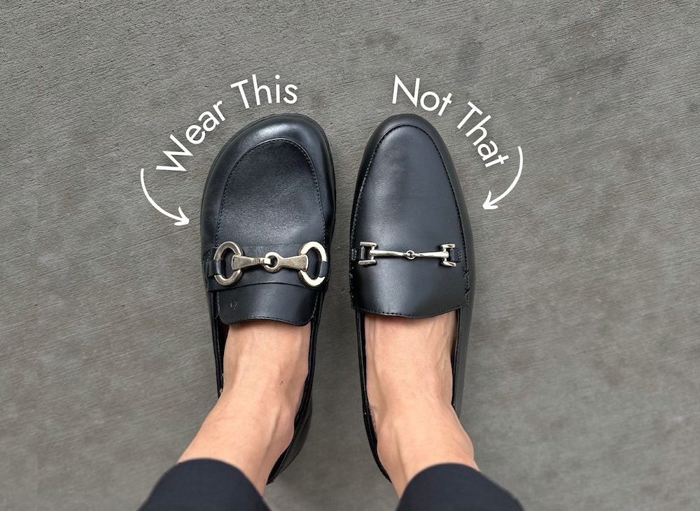Two black loafers with metal hardware side by side on a person's foot - on the left if a barefoot wide toe box foot shaped loafer with the text "Wear this" above it, and on the right is a point narrow black loafer with the text "not that" above it