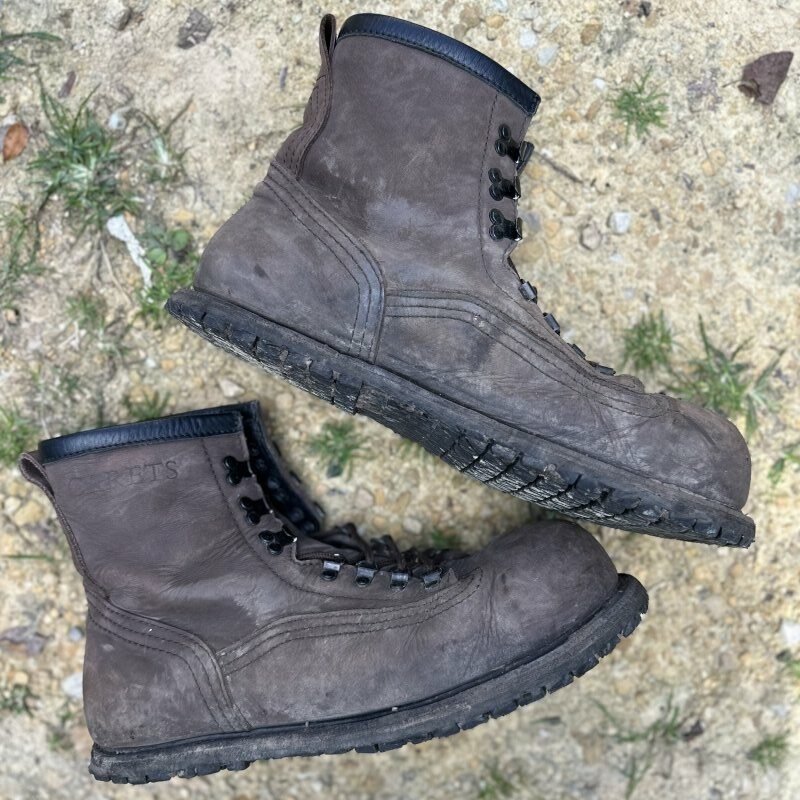 A pair of Carets Determination Steel Toe Safety boots with a zero drop outsole laid on their side in the gravel.
