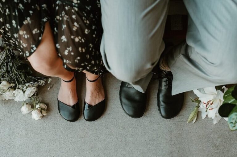 Knee down look at two people dressed up wearing barefoot shoes featuring Shapen Poppy in black, a wide toe box barefoot dress flat