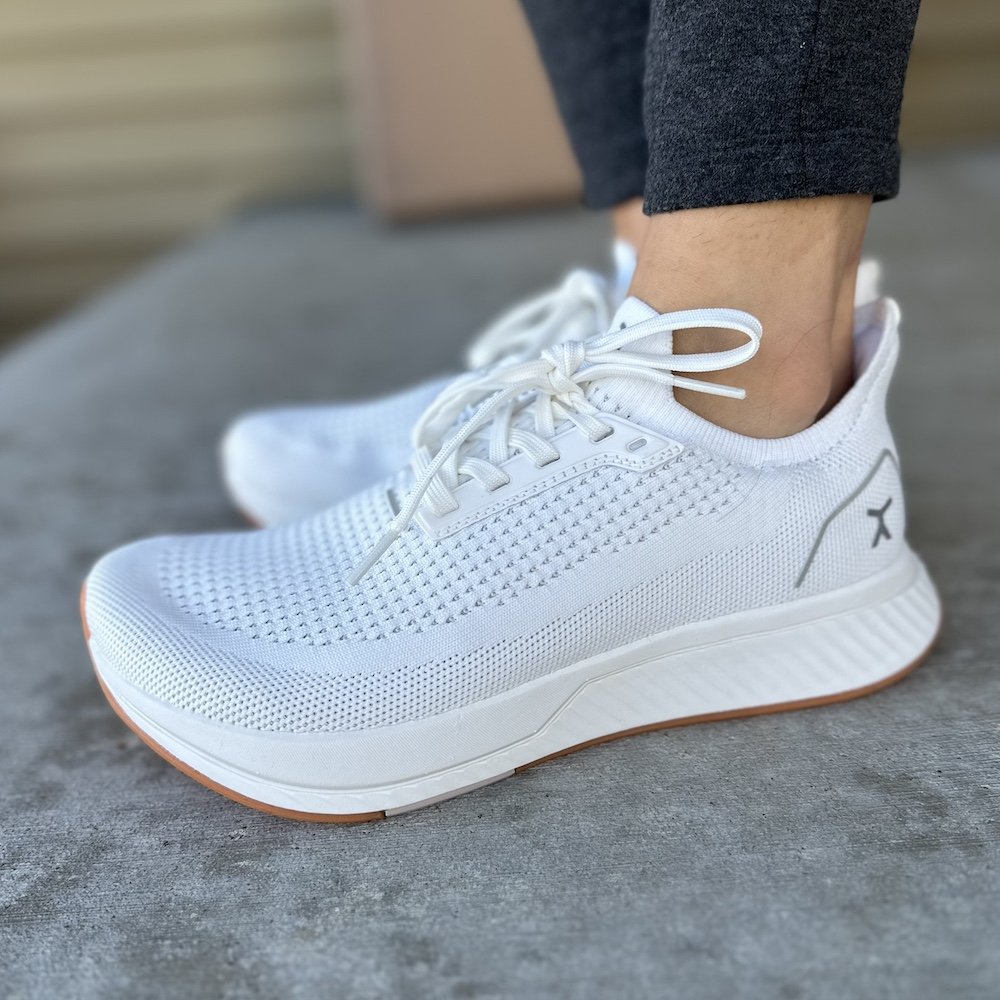 Front angled view of Topo Athletic wide toe box running shoes with a thick outsole being worn on concrete