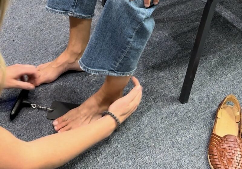 A close up of Jen from Gait Happens holding my foot with a toe strength dynamometer under the ball of my big toe to measure the strength output