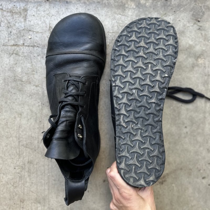 A pair of unworn Gaucho Ninja Carpenter's Steel Toe Safety boot with 1 boot turned over to show the outsole
