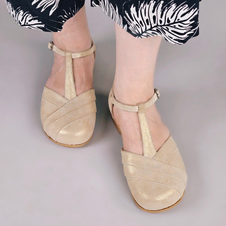 A pair of wide toe box shimmery t strap dance shoes for fancy occasions