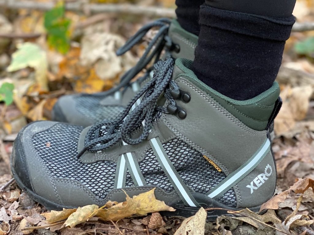 a close up of a pair of feet wearing the xero shoes waterproof vegan xcursion in green