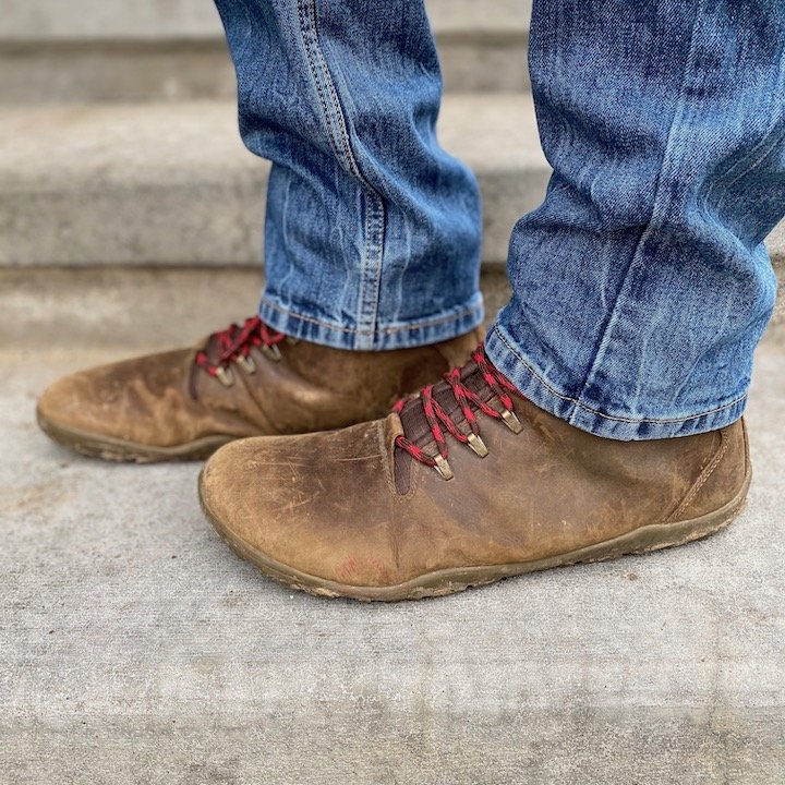 a close up of a pair of feet wearing the Vivobarefoot Tracker barefoot hiking boot