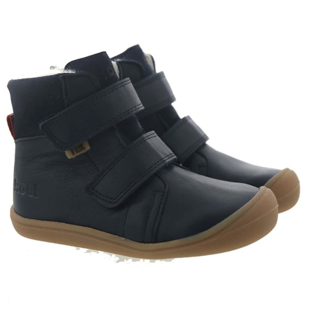 A side view of a pair of blue leather Koel Kids warm wool lined barefoot winter boots with velcro straps and a slip resistant outsole