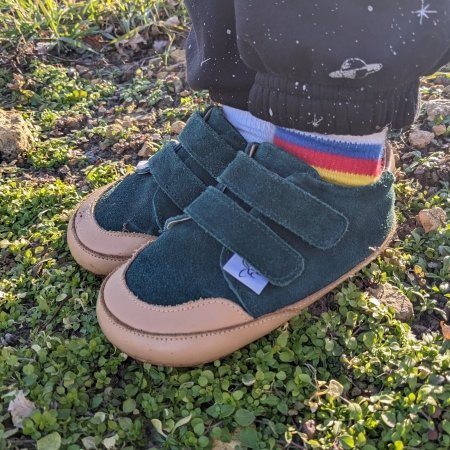 Side angled view of a little kid's feet in green barefoot dressy sneakers from Little Love Bug with double velcro straps and a zero drop sole1