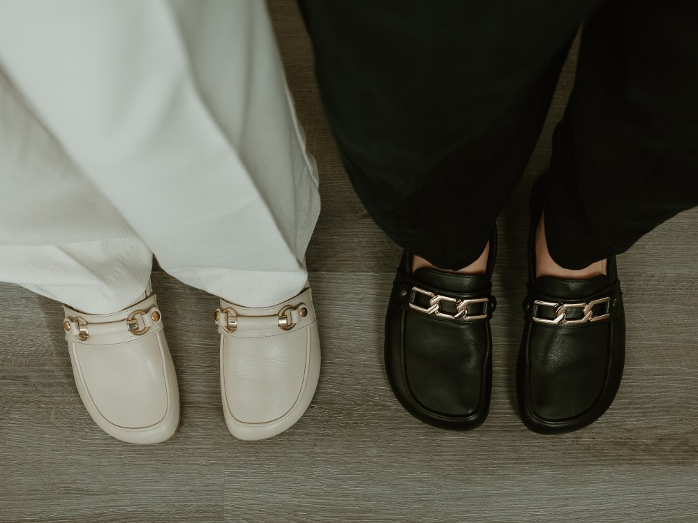 Top down view of two pairs of Shapen Barefoot Versa loafers in regular and wide width, both with a wide square shaped toe box.