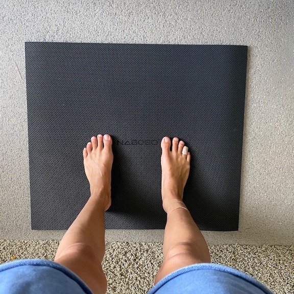 A woman's feet standing on Naboso desk mat