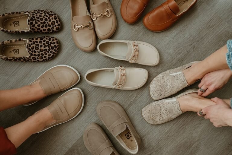 A collection of wide toe box barefoot loafers in neutral colors, prints, and stylish designs scattered around