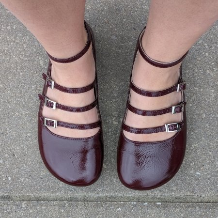 Top down view of Mary Jane flats with 3 straps plus an ankle strap in patent burgundy leather with a wide toe box