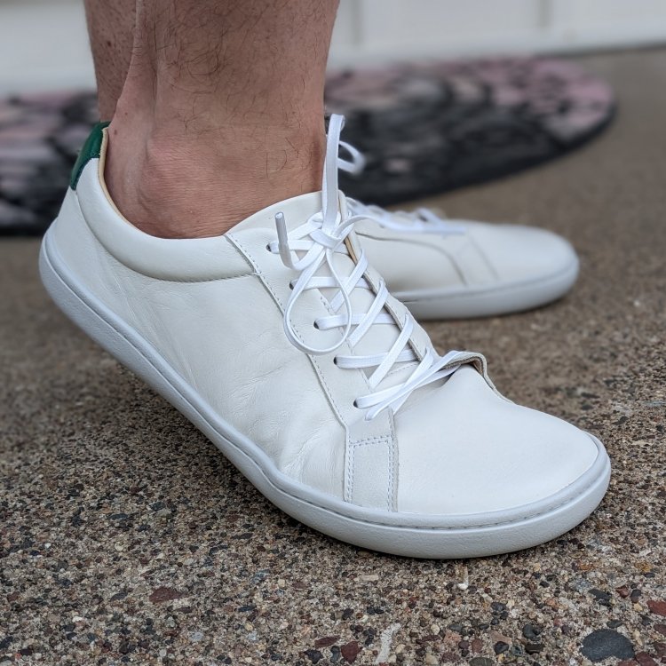 Front angled view of Origo Shoes Gen 3 wide barefoot leather sneakers in all white. The shoe closest to the camera is flexed up.