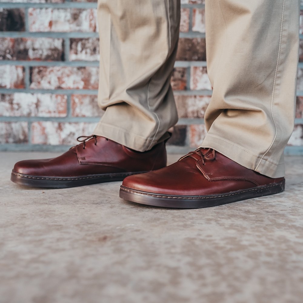 A close up side view of a man's feet wearing Peerko Smart men's barefoot dress shoes oxfords in brown