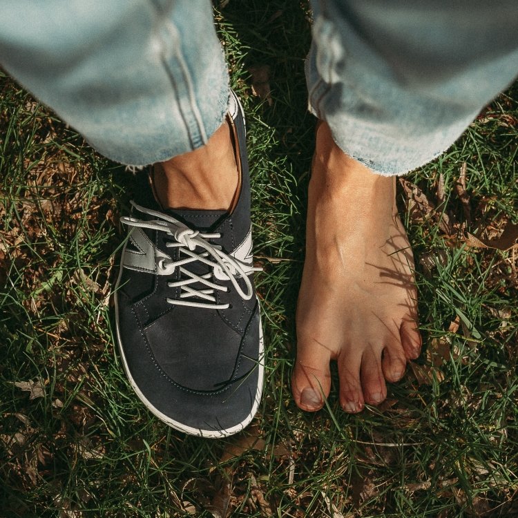 Top down view of a person with one foot off and one foot wearing Peerko street in navy to show the wide anatomical toe box