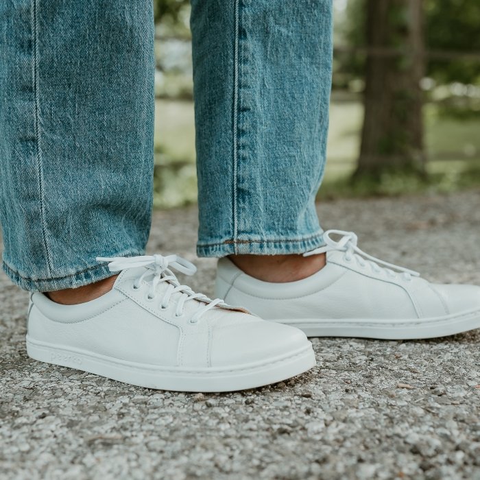 Close up of Peerko white leather sneakers shown from the side with show the zero drop flexible outsole