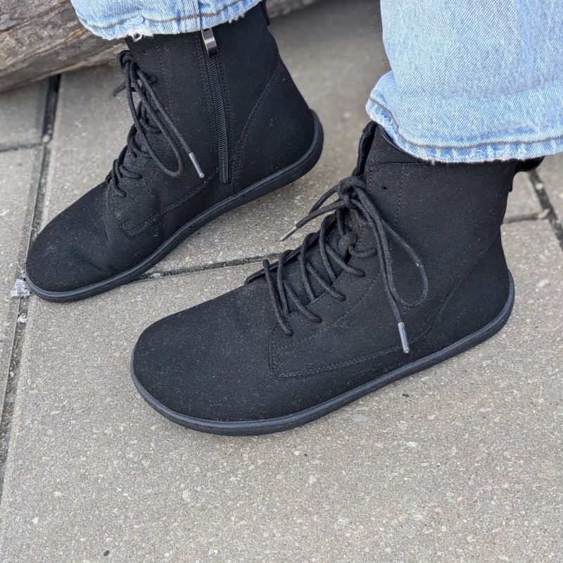 Side view of a pair of Ambition barefoot combat style boots from Saguaro Shoes with laces and a side zipper.