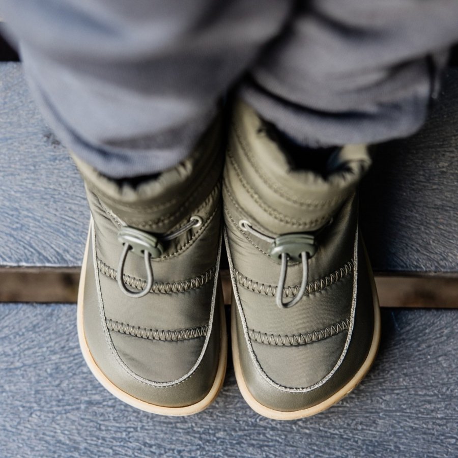 Top down close up of a pair of kids winter puffer boots with an extra wide toe box in olive green