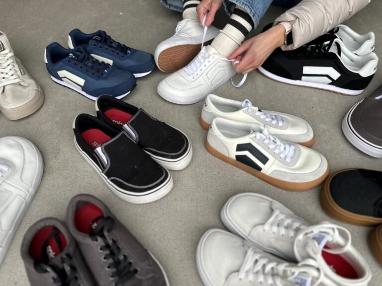 A person amongst a large number of Splay Shoes putting on one pair out of many. In the photos all new Splay Shoes are represented: Freestyle, 101, Streetstyle, Runners, Rev LT and HT.
