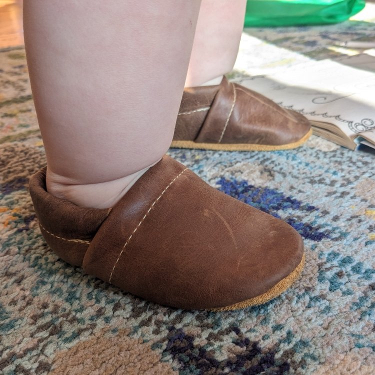 Starry Knight Design leather baby moccasins for new walkers being worn by a chubby toddler