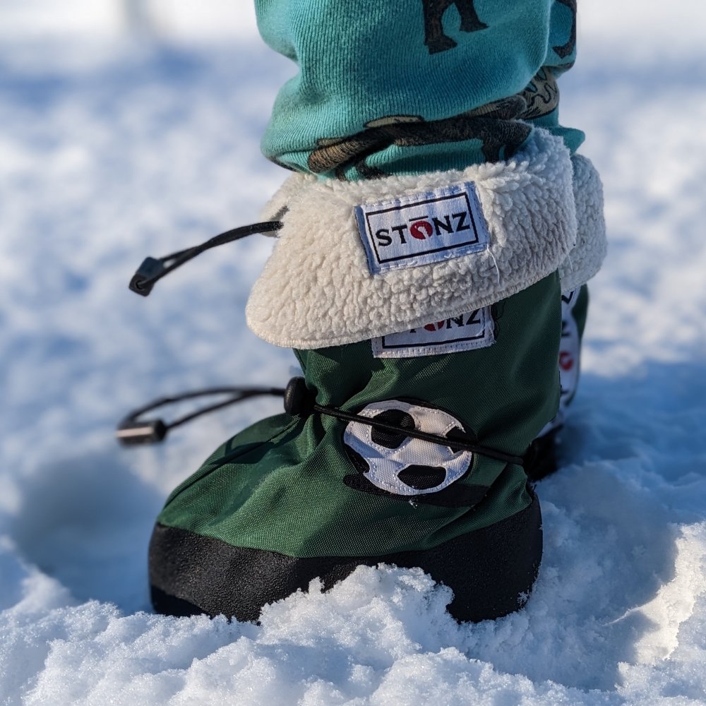 Stonz Soft Sole Winter Baby and toddler booties being worn in the slushy snow with sherpa liners