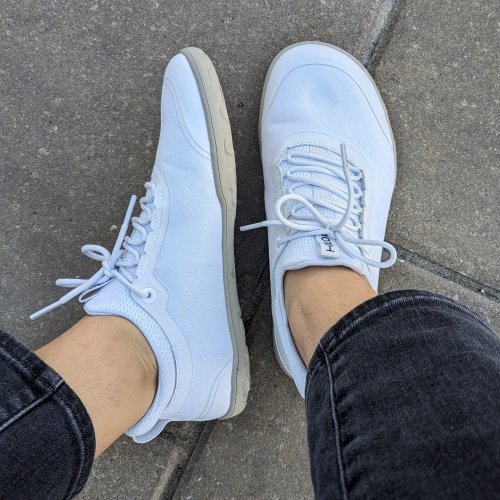 Tolos Barefoot lightweight sneakers with a wide toe box. Top and side view being worn by a person in jeans