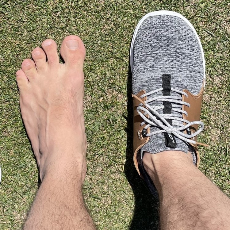 Top down view of foot bare and the other wearing True Linkswear OG Feel zero drop barefoot golf shoes with a wide toe box
