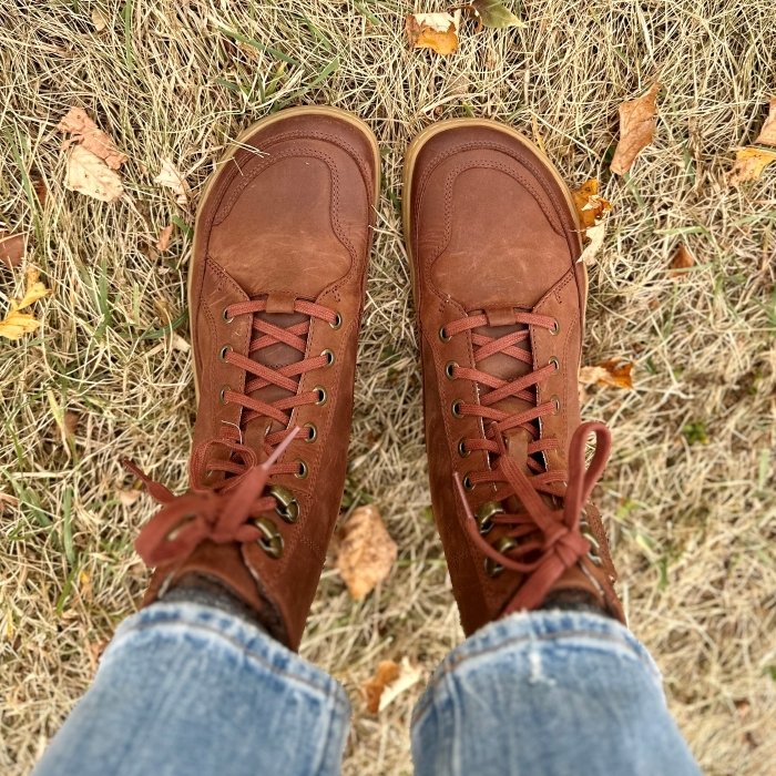 Top down view of a pair of legs wearing Vivobarefoot brown Gobi warm lined lace up leather boots