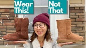 An image of a woman holding up the barefoot winter Dingo boot from Zeazoo Kids in one hand and the Uggs classic in the other hand with the text "Wear This! Not That" written above
