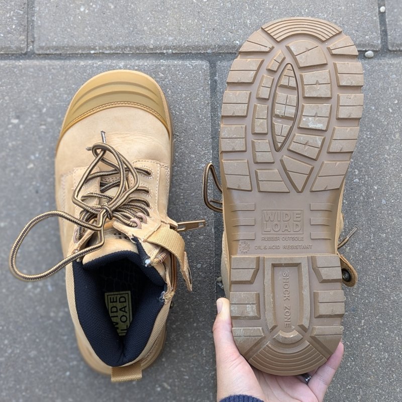 A pair of Wide Load Composite Toe work boots off the foot with 1 shoe showing the outsole shape and tread