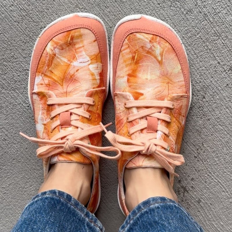 Top down view of sherbet orange butterfly print ultra lightweight barefoot shoes by Wildling Shoes