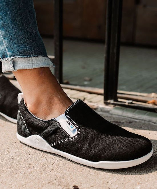 Close up side view of Xero Aptos, a barefoot black canvas slip on.