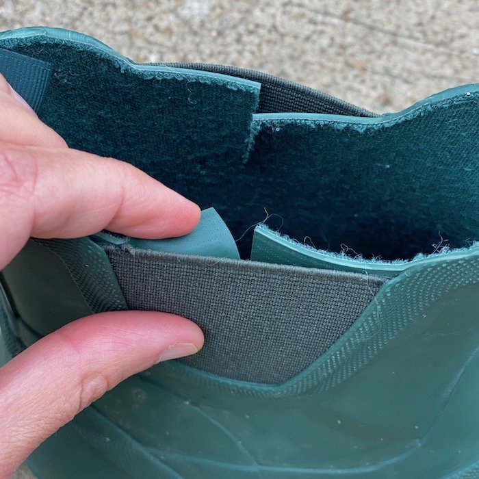 A close up of the elastic panels on a hunter green Xero Shoes Gracie rubber barefoot rain boot