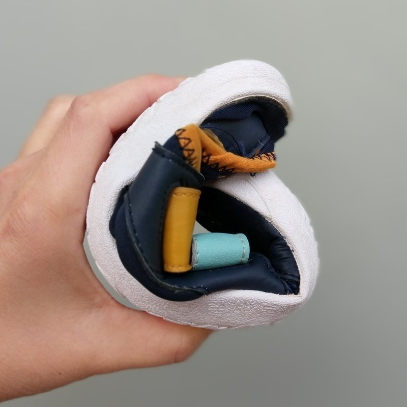 Zuna Shoes Akili big kids vegan barefoot sneakers rolled into a ball to show flexibility