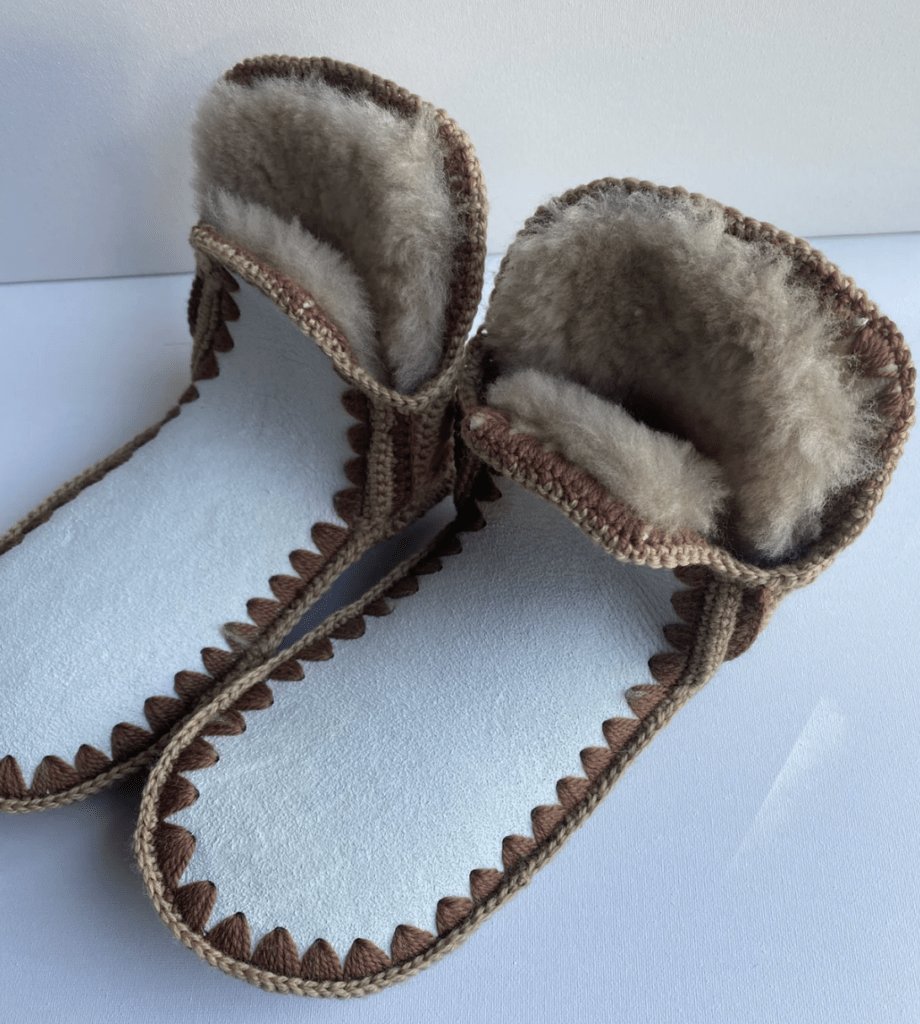 a stock photo of a pair of handmade sheepskin slippers with a wide toe box