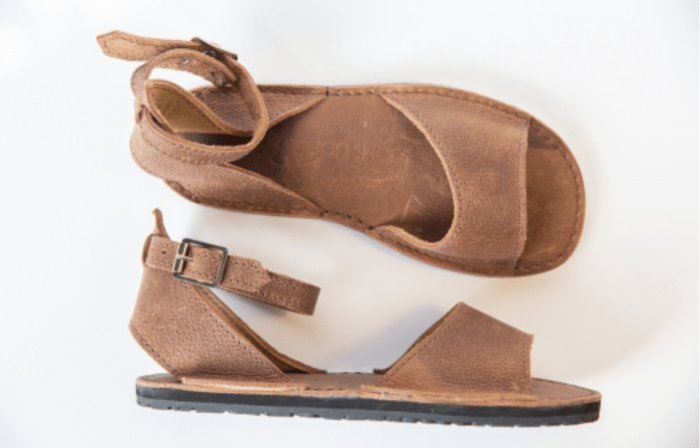 A pair of brown leather barefoot sandals with an ankle strap and thick forefoot strap shown on a white background