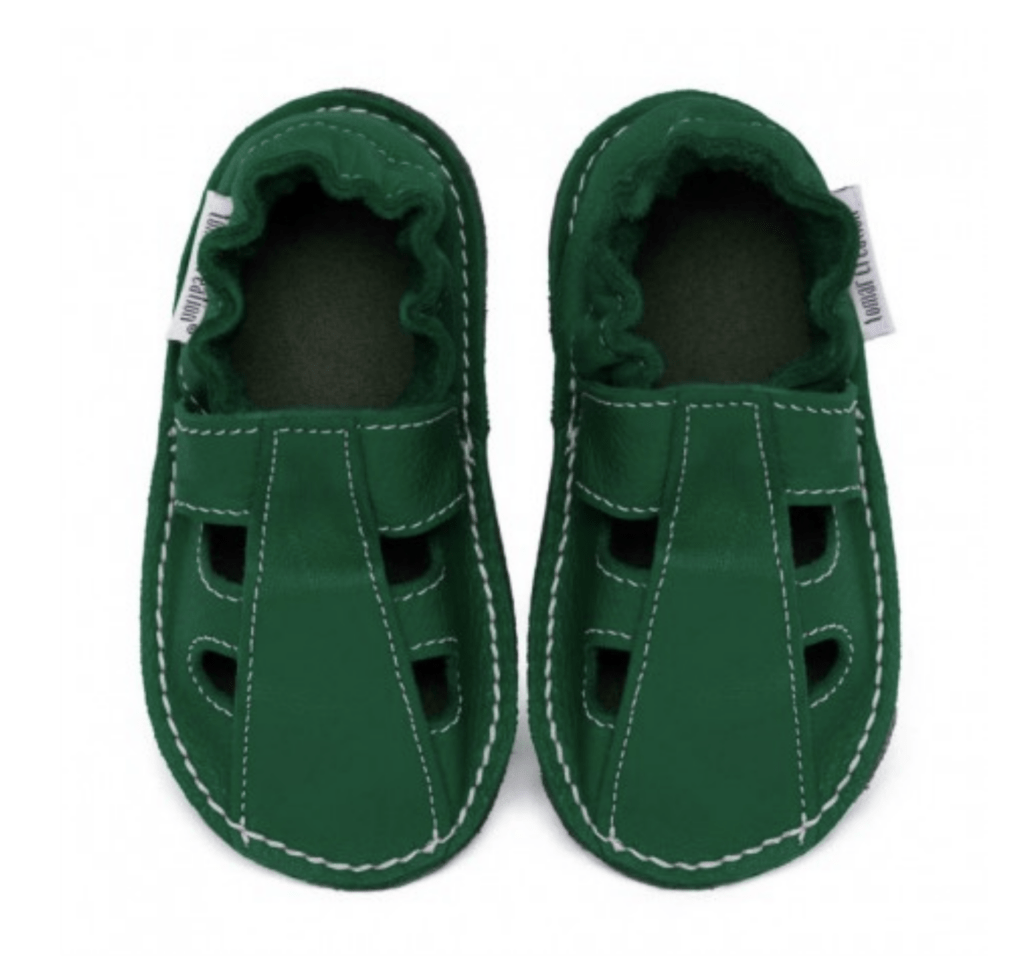 A pair of green leather kids sandals with elastic heel cuff shown on a white background