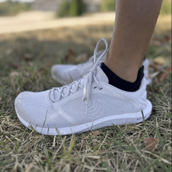 Side close up view of a person wearing Topo Athletics wide toe box flat zero drop outsole